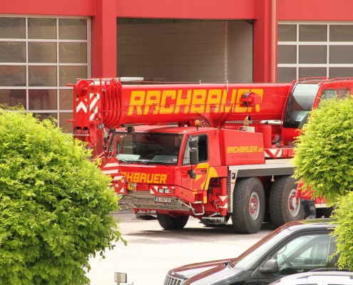 Rachbauer GmbH - Straßwalchen - Salzburg - Ihr starker Partner! - Kran - Mobilkran -90 Tonnen Autokran zwischen 2 Bäumen am Firmengelände